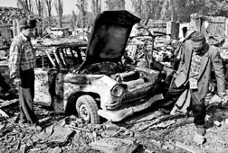 Dos lugareos inspeccionan un vehculo en medio de la destruccin ocasionada por los ataques areos rusos en la localidad de Elistanzhi, 45 kilmetros al suroeste de Grozny, la capital de Chechenia n Foto: Ap