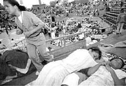 Una doctora camina entre damnificados concentrados en un estadio de Caracas n Fotos: Ap