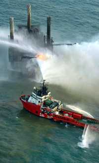 Aspecto del incendio en la plataforma Usumacinta. Embarcaciones arrojan chorros de agua para controlar el fuego