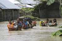 Habitantes del estado indio de Bihar, afectados por los anegamientos, cargan sus pertenencias en espera de ser auxiliados por equipos de rescate