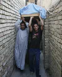 Iraquíes conducen el ataúd de un hombre fallecido en su casa durante un bombazo en Badgad. El estallido del artefacto, sembrado en un auto estacionado, causó la muerte de nueve personas y dejó heridas a 13 en el distrito de Bayaa, al sur de esa capital