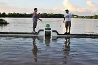 Dos hombres conversan arriba del borde del malecón de Tenosique, Tabasco, prácticamente cubierto por el río Usumacinta, que rebasó su altura histórica y afectó 238 localidades y a más de 14 mil familias