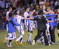 Compañeros del portero tuzo Miguel Calero lo felicitan por detener el penal definitivo en la larga serie ante Zorros